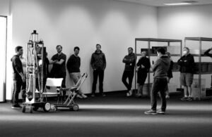 scene with engineers gathered around a prototype of a mobile robot.