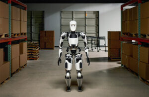 the apptronik humanoid robot Apollo stands in a warehouse aisle.